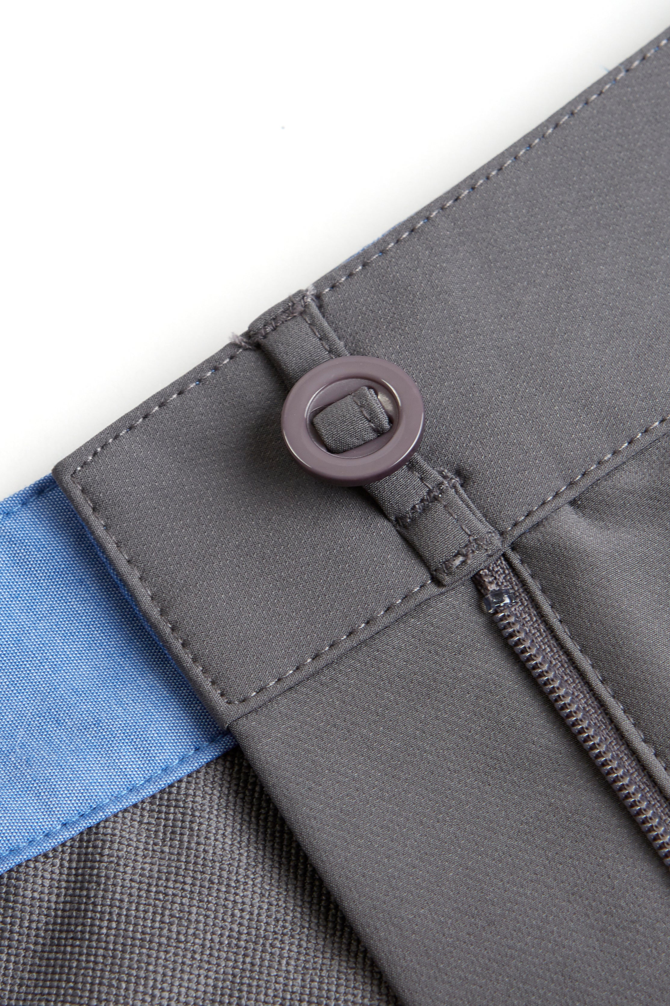 Close-up of a gray fabric with a zipper and blue trim on a white background. grey chino deck shorts. Women's deck shorts. Yachtwear, workwear