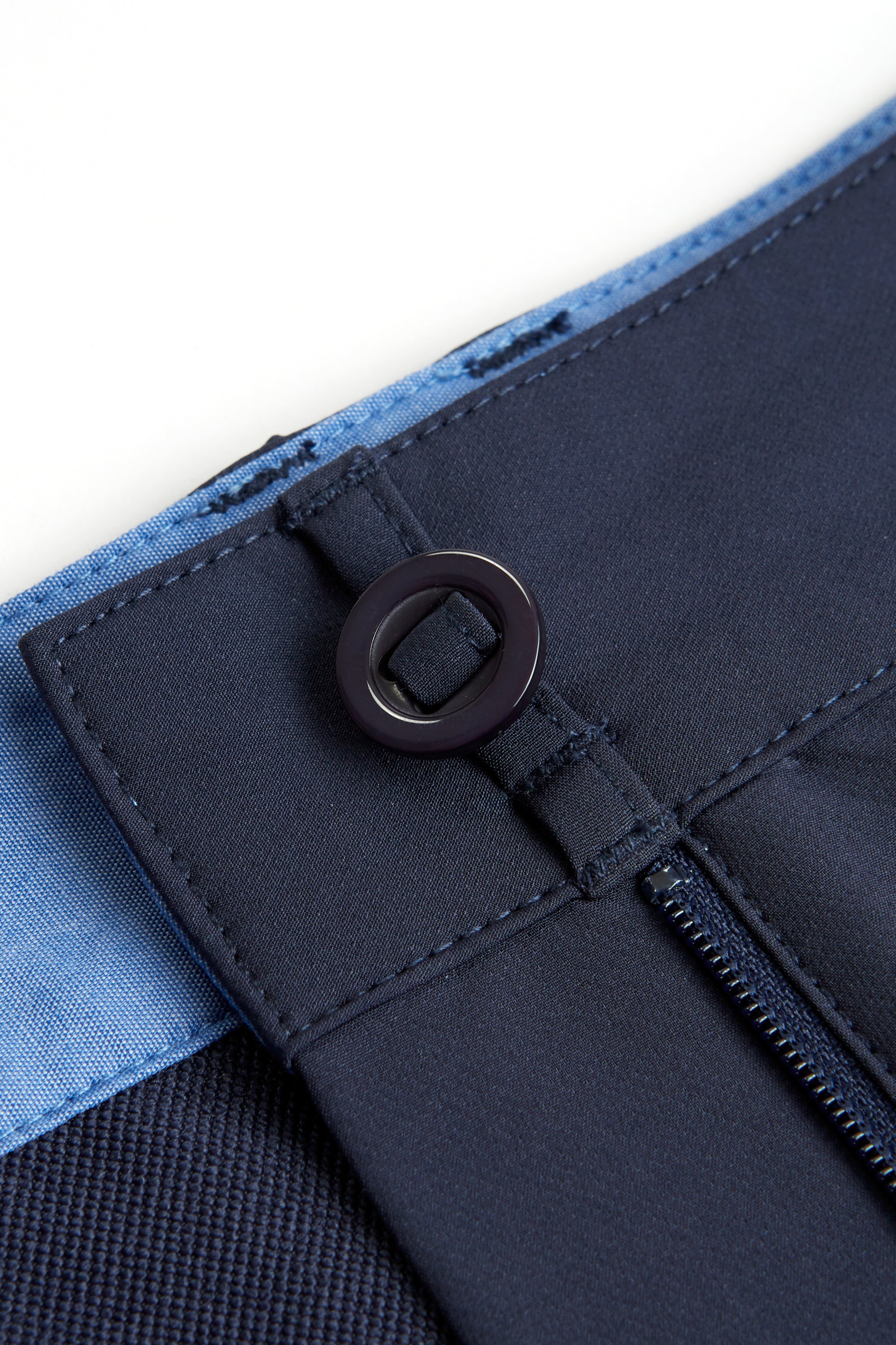 Close-up of a navy chino shorts with a button and zipper on a white background. Women's deck short. yachtwear, workwear