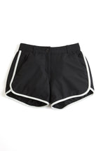 Black shorts with white trim on a white background. black shorts on a white background. Women's deck shorts. Yachtwear, workwear