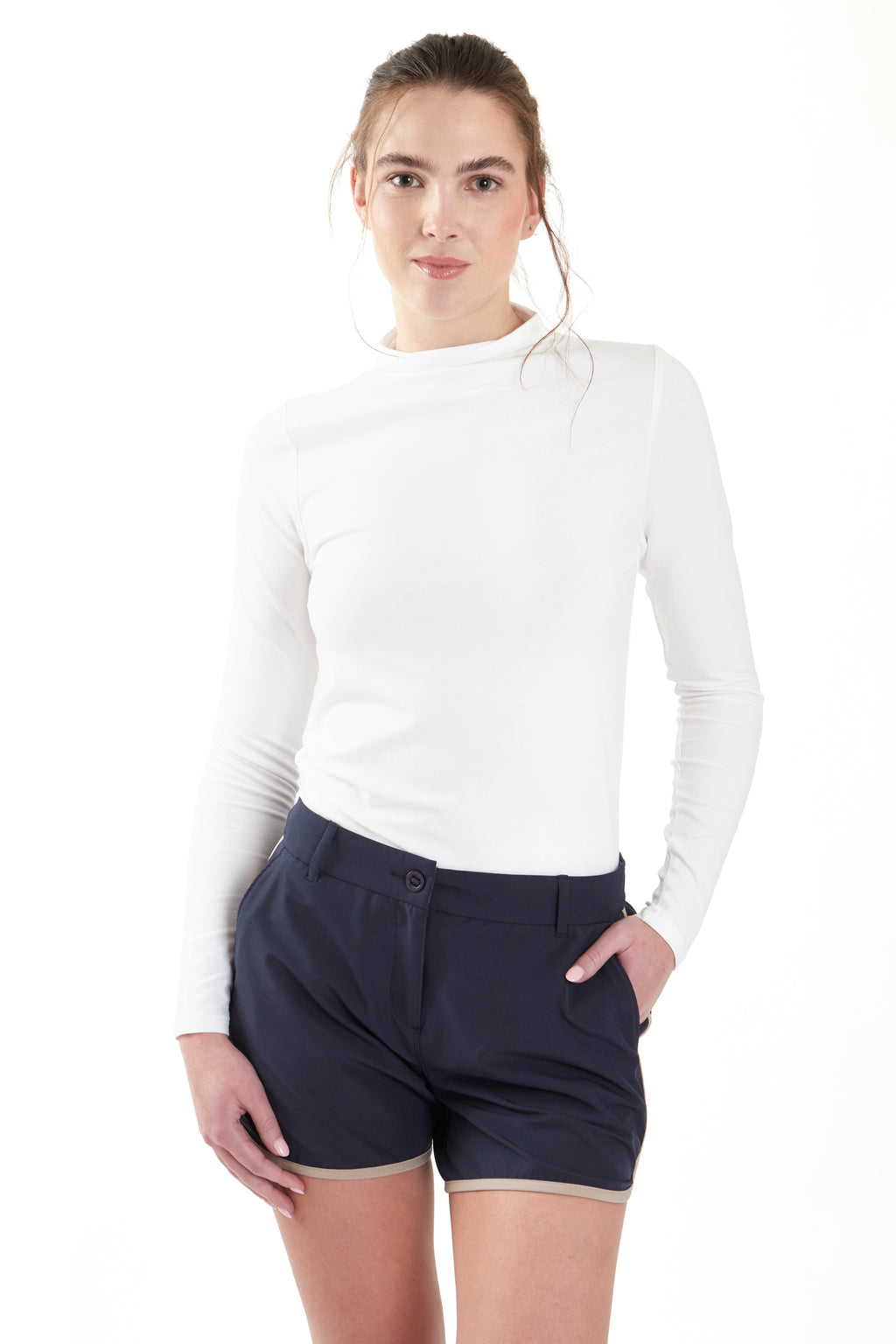 Woman wearing a white long-sleeve top and navy shorts on a white background. Women's deck shorts. Yachtwear, workwear