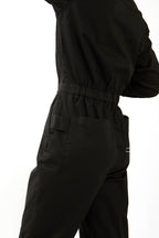 Woman in black boiler suit / coveralls. Workwear, streetwear. Workwear style